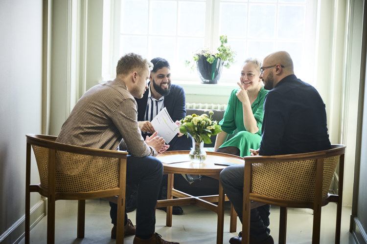 Adan og tre andre medarbejdere i departementet diskuterer en sag