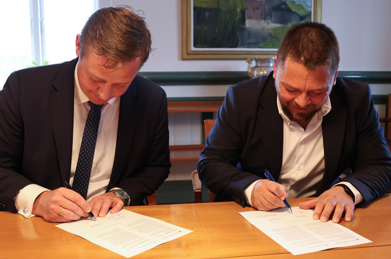 Transportminister Thomas Danielsen og den færøske transportminister Jóhan Christiansen underskriver aftalen om, at Færøerne overtager ansvaret for luftfartsområdet.