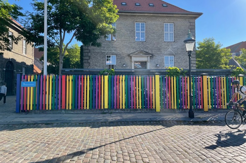 Transportministeriets indgang med skilt og stakit, der er malet regnbuefarvet.