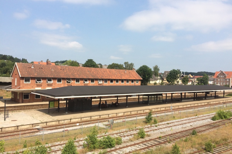 Langå Stations stationsbygning og sporene ses foran.