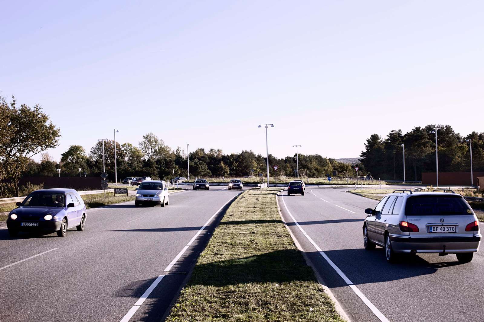 Genrefoto af biler på en tosporet vej med en rundkørsel forude