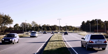 Genrefoto af biler på en tosporet vej med en rundkørsel forude